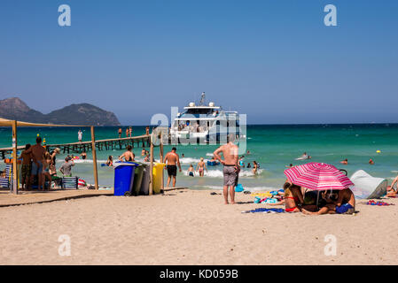 Touristen beobachten Kreuzfahrtschiff Ankunft an der Playa de Muro in der Bucht von Alcudia, Mallorca Stockfoto