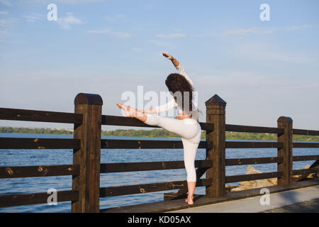 Junge schwangere Yoga im Freien. schwanger Yoga. Frauen, verschiedene Übungen. Fluss auf Hintergrund. Konzept der gesunden Lebensweise und Relaxa Stockfoto