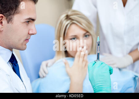 Angst Patienten an den Zahnarzt, der auf die Vorbereitung der Injektion suchen Stockfoto
