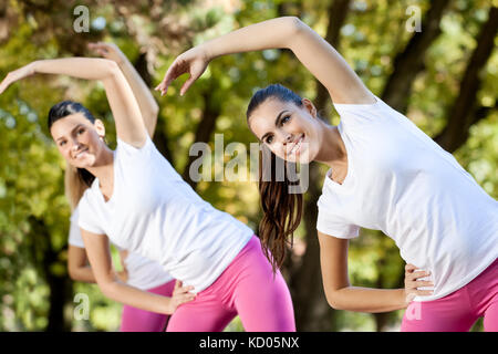 Junge Frauen stretching auf Aerobic, outdoor Stockfoto