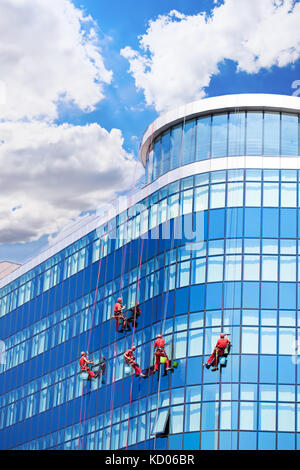 Arbeitnehmer windows Waschen im Bürogebäude Stockfoto