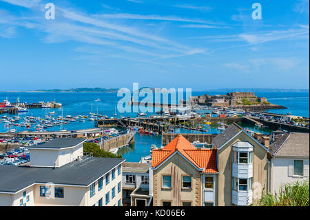 Hohen winkel Blick über den Hafen von St. Peter Port, Guernsey, Channel Islands, Großbritannien. Die Inseln Herm und Sark sind in der Ferne zu sehen. Stockfoto