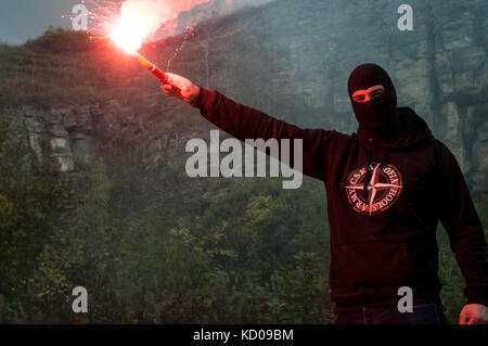 Osteuropäischen Fußball-Hooligan Stände mit einer Signalpistole beleuchtet. Stockfoto