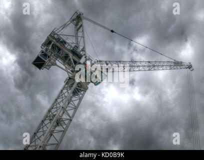 Baustelle Turm Kran gesehen von unten mit stürmischen graue Wolken am Himmel Stockfoto