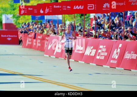 Ein lächelndes Galen Rupp, ganz allein in der Zielgeraden Momente weg von der Ziellinie und gewann die Chicago Marathon 2017. Chicago, Illinois, USA. Stockfoto