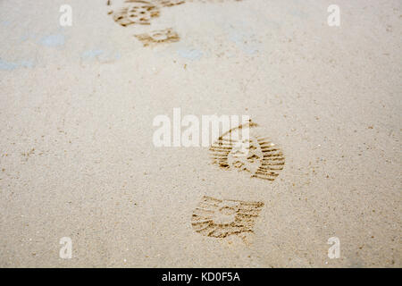 Mehrere Abdrücke von Schuhen in den Sand von der Vorderseite Stockfoto