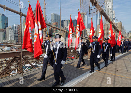 NEW YORK CITY, USA, 11. September 2017 : die Feuerwehrleute von New York gehen auf der Brooklyn Bridge während der Gedenkfeier der 9/11 Anschläge. Stockfoto