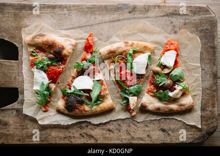 Pizza Slices auf Schneidebrett, Ansicht von oben Stockfoto