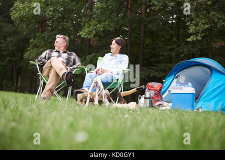 Reifes Paar sitzen in camping Stühle neben Zelt, Low Angle View Stockfoto