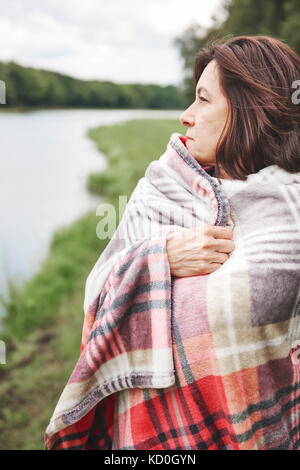 Reife Frau in ländlicher Umgebung, in der Decke eingewickelt Stockfoto