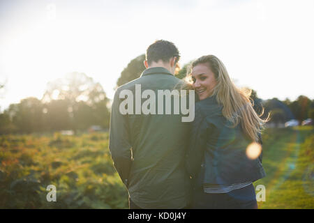 Ansicht der Rückseite des jungen Paares schlendern Arm in Arm im Feld Stockfoto