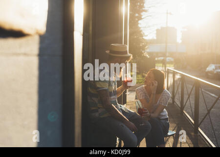 Paar draußen sitzen sonnenbeschienenen Sidewalk Cafe Cocktails in Stockfoto