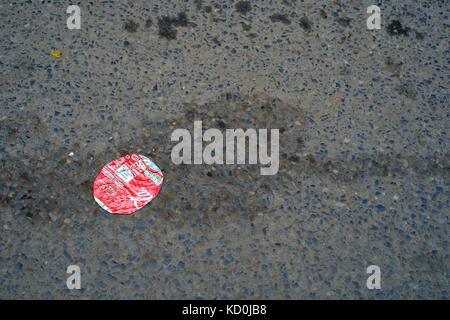 Abgeflachte leer Coca Cola Dose gegen die Straße Asphalt England uk abgeflacht Stockfoto