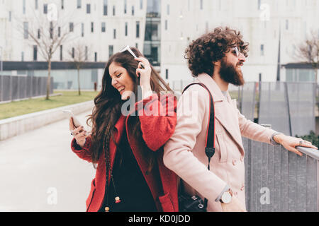 Junges Paar im Freien, jungen Frau an Smartphone suchen, Lachen Stockfoto