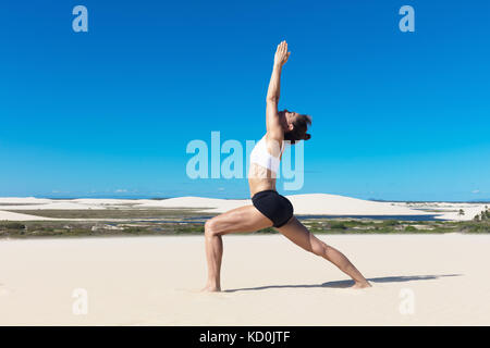 Seitenansicht der Frau am Strand angehoben Stretching in Yoga Position Stockfoto