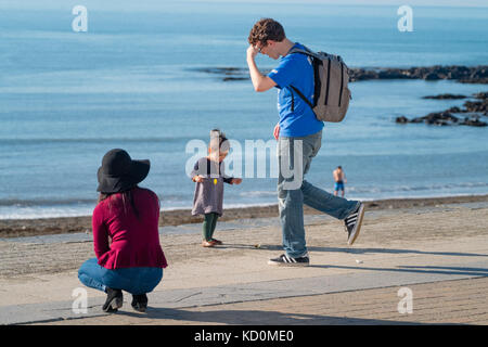 Aberystwyth Wales UK, Sonntag, 08. Oktober 2017 UK Wetter: Menschen am Meer in Aberystwyth Wales genießen einen wunderbar warmen und sonnigen Herbst Sonntagnachmittag Foto: Keith Morris/Alamy Live News Stockfoto