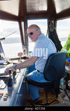 Kapitän der Valentia Island Car Ferry am Steuer Stockfoto