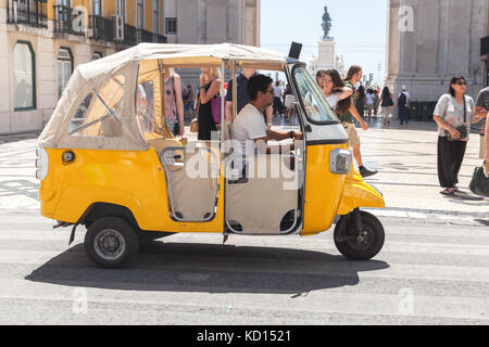 Lissabon, Portugal - 12. August 2017: Gelbes Tuk Tuk-Taxi mit Fahrer fährt auf der Straße von Lissabon Stockfoto