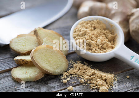 Ingwer Wurzel, Scheiben, und Pulver mit Messer im Hintergrund. Stockfoto