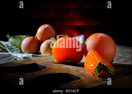 In der Nähe von frischem Kaki nur nach der alten hölzernen Schneidebrett Stockfoto