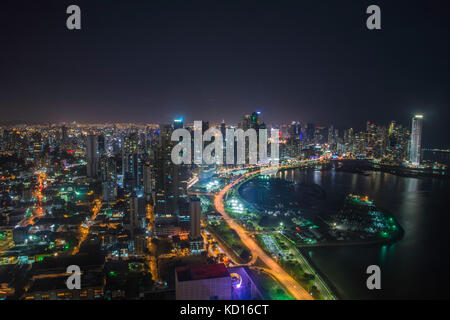 Das blaue Licht der Dämmerung leuchtet ein Block von Hochhäusern über den Streifen Rote Rücklichter des Schnellfahrens Autos auf Balboa Avenue in Panama City. Die stre Stockfoto