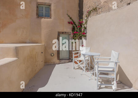 Balkon mit zwei Stühlen. und minimalistischen Blumen. Santorini, Griechenland. Stockfoto
