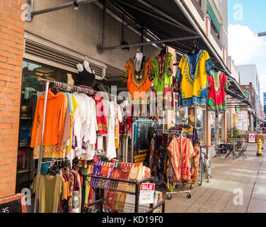 Bunte Kleidung hängen draußen auf dem Bürgersteig entlang Baldwin st. in Kensington Market in der Innenstadt von Toronto, Ontario, Canada. Stockfoto