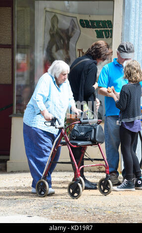 Ältere Frau mit einer Gehhilfe oder Sitz Walker auf der Straße Stockfoto