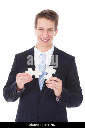 Junge Unternehmer holding Puzzle auf weißem Hintergrund Stockfoto