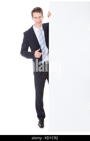 Portrait der junge Geschäftsmann Holding leere Plakette auf weißem Hintergrund Stockfoto