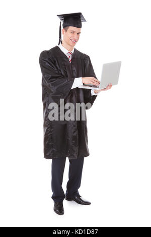 Junge Absolventen Mann mit Laptop Over White Background Stockfoto