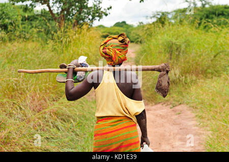 Afrikanische Frau, die mit der Hacke auf dem Feld zu arbeiten Stockfoto