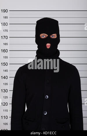 Einbrecher tragen Balaclava stehend gegen Polizei lineup Stockfoto