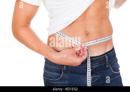 Nahaufnahme der junge Mann seine Taille messen Stockfoto