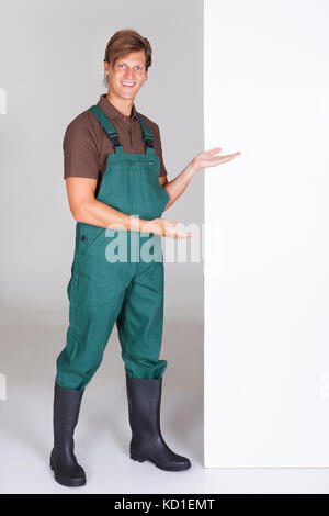 Glückliche junge männliche Gärtner Vorlage Leeres Plakat Stockfoto
