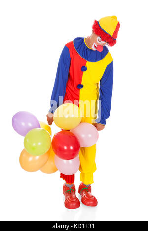 Porträt eines traurigen Clowns mit Multi-farbigen Ballons auf weißem Hintergrund Stockfoto