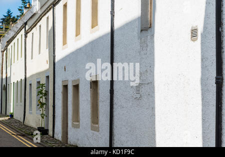 Schottische typische Reihenhäuser Häuser des Dorfes mit einem einzigen grüne Pflanze Typ Tyree außerhalb einer der Türen. Eine typische Zeile Reihenhäuser häufig in gesehen Stockfoto