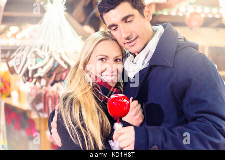 Paar mit süßen Apfel auf Weihnachtsmarkt Stockfoto
