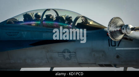 Ein U.S. Navy F/A-18E Super Hornet fährt nach Erhalt Kraftstoff aus einem 340 Expeditionary Air Refuelling Squadron KC-135 Stratotanker Stockfoto