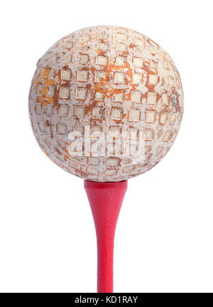 Alte Golf Ball auf ein rotes T-Stück auf einem weißen Hintergrund. Stockfoto