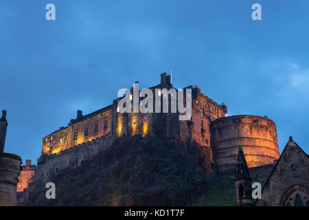 Das Edinburgh Castle leuchtet während der Blauen Stunde vom Grassmarket Stockfoto