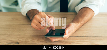 In die Hände der erfolgreiche Geschäftsmann smartphone. Nach kaukasischen business Person im weißen Hemd mit aufgezogen gerollt Ärmel mit Handy Stockfoto