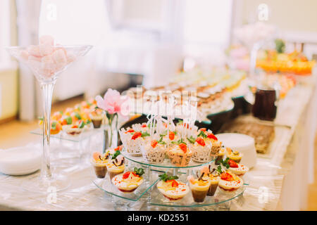 Blick auf den liebevoll dekorierten Desserts auf der Hochzeit Tisch platziert. Stockfoto
