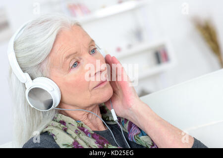 Alte Dame mit Kopfhörer auf Stockfoto
