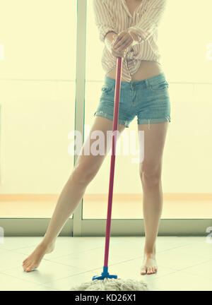 Frau mit Mopp, der den Boden putzt. Stockfoto