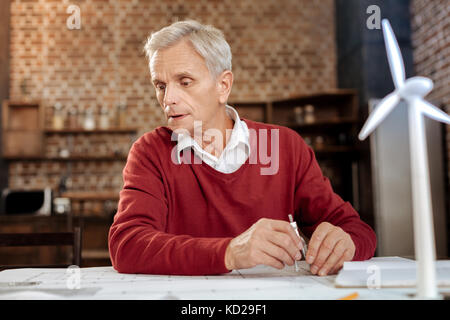 Grauhaariger Mann mit Kompass Bauplan zu zeichnen Stockfoto