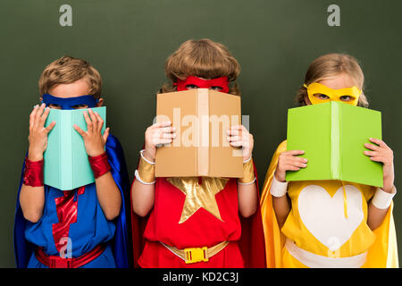 Wenig Superhelden mit Bücher Stockfoto