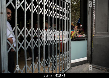 Ein Sicherheitsbeamter beobachtet einen Streik mit geschlossenem Zaun beim katalanischen Generalstreik am 3. oktober in Barcelona. Quelle: Alamy / Carles Desfilis Stockfoto