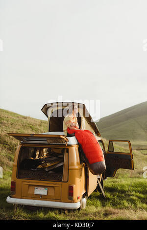 Junge männliche skateboarder Blick von der Oberseite des Vintage recreational vehicle, Exeter, Kalifornien, USA Stockfoto
