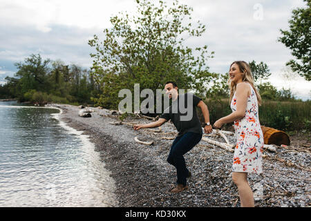 Paar skimming Steine am Strand, Oshawa, Kanada Stockfoto